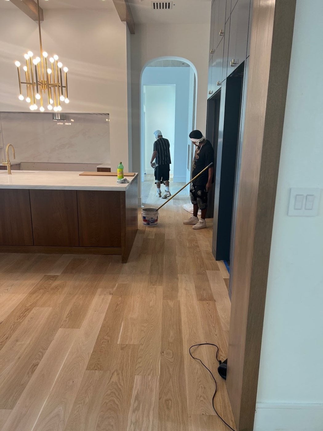 Applying a finish coat to a refinished hardwood floor in a DFW home