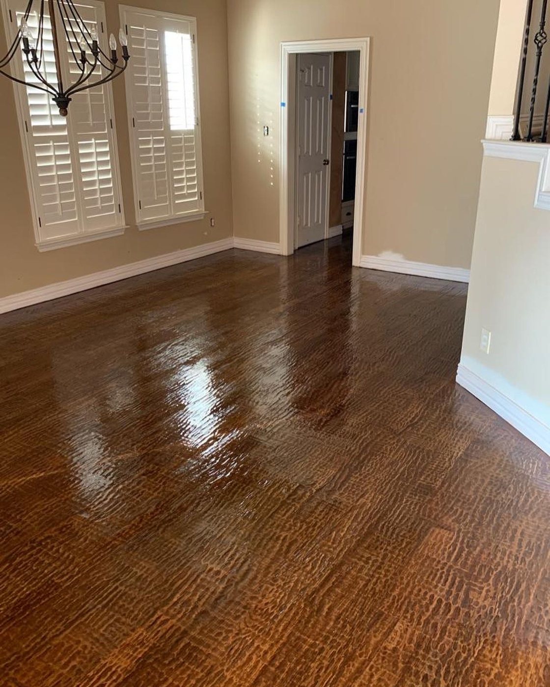 Glossy hardwood floor refreshed with a screen and recoat (Finished glossy hardwood floor in empty room)
